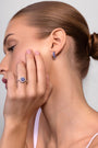 Nik Jewellery Azure 18K white gold blue sapphire baguette huggie earring worn on ear, showing 10 mm diameter and fit.